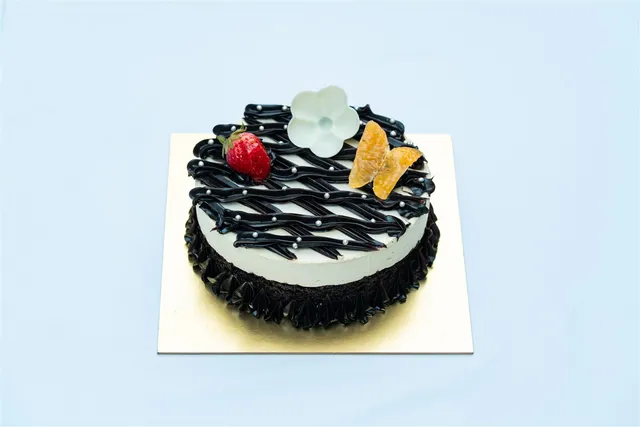 Black and white decorated cake with fruit topping